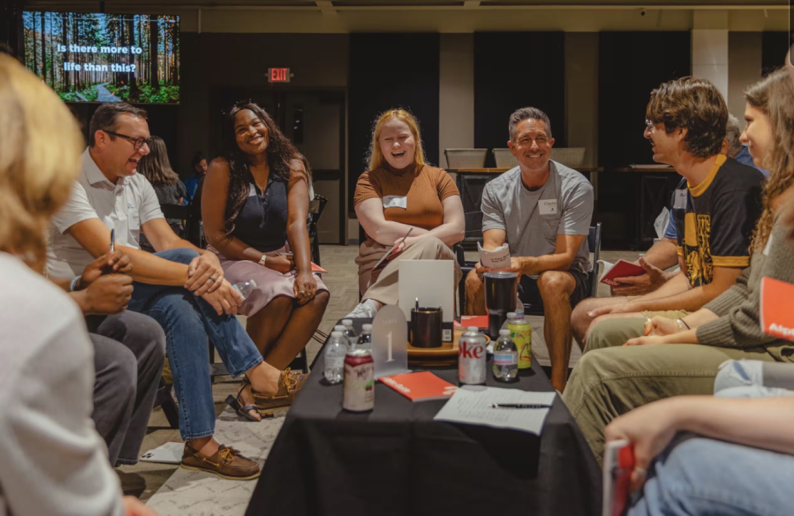 A table group of parents and teens mid-conversation